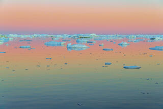 Remains of an Iceberg field in the setting midnight sun on Disko Bay Greenland.