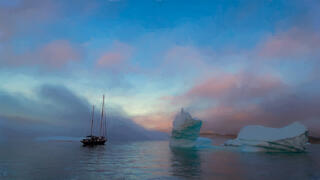 boat without sails up on Disko Bay Greenland with sea mist rolling in during the midnight sunset.