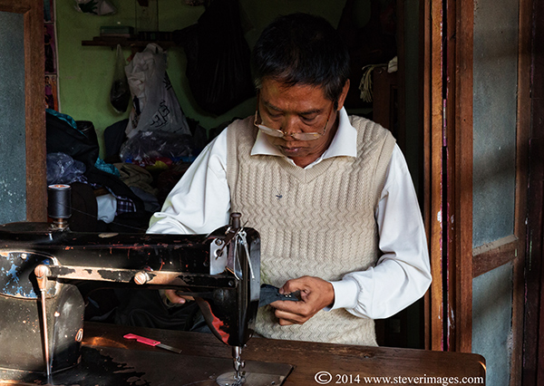 There were a number of people working at the back of the market sowing and making/reparing garments, both men and women.